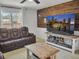 Cozy living room with wood accent wall, media console, and comfortable brown leather sofa at 5460 Wheeler Ridge Rd, Auburn, GA 30011
