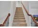 Carpeted staircase with decorative wood railing at 5460 Wheeler Ridge Rd, Auburn, GA 30011