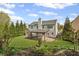 Backyard view of the home's exterior featuring a covered patio and lush greenery at 6655 Grove Meadows Ln, Cumming, GA 30028