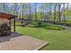 Landscaped backyard featuring a patio, fireplace, and a wooden fence bordering the property at 6655 Grove Meadows Ln, Cumming, GA 30028