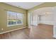 Open-concept dining room with hardwood floors, columns, and a large window at 6655 Grove Meadows Ln, Cumming, GA 30028