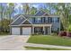 Charming two-story home with a three car garage and manicured lawn at 6655 Grove Meadows Ln, Cumming, GA 30028