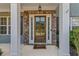 Stylish entryway with stone accents, white columns, and a secure glass door at 6655 Grove Meadows Ln, Cumming, GA 30028