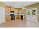 Modern kitchen featuring black appliances, granite counters and outdoor access at 6655 Grove Meadows Ln, Cumming, GA 30028