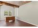 Bright office space with wooden ceiling beams and a large wooden desk at 6655 Grove Meadows Ln, Cumming, GA 30028