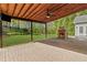 Spacious covered patio with stone fireplace, ceiling fan, and a view of the landscaped backyard at 6655 Grove Meadows Ln, Cumming, GA 30028