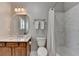 Well-lit bathroom with a wooden vanity, tiled shower, and marble accents, designed for comfort and style at 7512 Portbury Park Ln, Suwanee, GA 30024