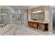 Elegant bathroom with a large soaking tub, seamless glass shower, and beautifully crafted wooden vanity at 7512 Portbury Park Ln, Suwanee, GA 30024