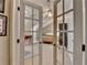View through French doors into a bright bedroom with neutral decor at 7512 Portbury Park Ln, Suwanee, GA 30024