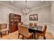 Formal dining room with hardwood floors, elegant chandelier, and decorative moldings at 7512 Portbury Park Ln, Suwanee, GA 30024