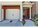 Charming townhome showing the 2 car garage, front entrance, and brick facade at 7512 Portbury Park Ln, Suwanee, GA 30024