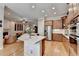 Open-concept kitchen showcasing a center island, stainless steel appliances, and seamless flow to the living area at 7512 Portbury Park Ln, Suwanee, GA 30024
