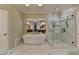 Luxurious bathroom featuring a soaking tub and a separate glass-enclosed shower with beautiful marble tile at 7512 Portbury Park Ln, Suwanee, GA 30024