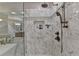 Detailed view of the shower with elegant marble tiling and modern fixtures and shower niche at 7512 Portbury Park Ln, Suwanee, GA 30024