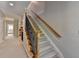 Carpeted staircase with decorative black iron railings and wooden handrail at 7512 Portbury Park Ln, Suwanee, GA 30024