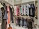 Well-organized walk-in closet with shelving and hanging rods, providing ample storage for clothing at 7512 Portbury Park Ln, Suwanee, GA 30024