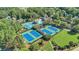 Aerial shot of tennis courts, playground, pool and clubhouse nestled in a wooded community at 9250 Nesbit Lakes Dr, Alpharetta, GA 30022