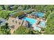 Aerial view of the community pool, clubhouse, and tennis courts nestled among green trees at 9250 Nesbit Lakes Dr, Alpharetta, GA 30022