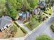 Stunning aerial view of a red brick home with a pool, lush landscaping, and a circular driveway at 9250 Nesbit Lakes Dr, Alpharetta, GA 30022