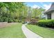Well-maintained backyard featuring a lush lawn, landscaping, and a walkway leading to the pool at 9250 Nesbit Lakes Dr, Alpharetta, GA 30022