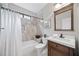 Updated bathroom featuring a tub with shower, a stylish vanity, and tiled walls at 9250 Nesbit Lakes Dr, Alpharetta, GA 30022