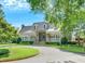 Clubhouse with white columns, a covered porch, circular driveway, and landscaped grounds at 9250 Nesbit Lakes Dr, Alpharetta, GA 30022