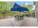 Spacious deck area with comfortable outdoor seating, dining area, and shade umbrella overlooking the pool at 9250 Nesbit Lakes Dr, Alpharetta, GA 30022