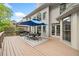 Spacious wooden deck featuring a dining table, grill, and views of the landscaped backyard at 9250 Nesbit Lakes Dr, Alpharetta, GA 30022