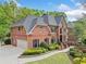 Spacious brick home with an attached garage, well-maintained lawn, and mature trees at 9250 Nesbit Lakes Dr, Alpharetta, GA 30022