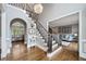 Open foyer with hardwood floors, staircase, chandelier, and views into adjacent rooms at 9250 Nesbit Lakes Dr, Alpharetta, GA 30022