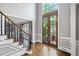 Bright foyer with hardwood floors, staircase, and a large windowed front door at 9250 Nesbit Lakes Dr, Alpharetta, GA 30022