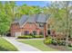 Beautiful two story brick home with a meticulously maintained lawn and mature landscaping at 9250 Nesbit Lakes Dr, Alpharetta, GA 30022