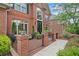 Charming brick home featuring a wrought iron gated courtyard, front porch, and landscaped yard at 9250 Nesbit Lakes Dr, Alpharetta, GA 30022