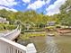 Picturesque view of the lake with bridge and homes on the other side surrounded by lush greenery at 9250 Nesbit Lakes Dr, Alpharetta, GA 30022