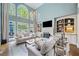 Open living room with large windows, built-ins, and neutral-toned furniture at 9250 Nesbit Lakes Dr, Alpharetta, GA 30022