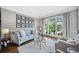 Cozy living room featuring a blue sofa, picture gallery wall, and large window at 9250 Nesbit Lakes Dr, Alpharetta, GA 30022