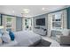 Bright main bedroom with three large windows, TV, neutral colors, and an inviting seating area at 9250 Nesbit Lakes Dr, Alpharetta, GA 30022