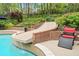 The inviting backyard pool has a slide, landscaping, and comfortable lounge chairs at 9250 Nesbit Lakes Dr, Alpharetta, GA 30022