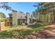 Spacious, grassy backyard with a beautiful green home, chimney, patio, and lovely landscaping on a sunny day at 116 Edgeview Ct, Dallas, GA 30157