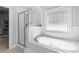 Relaxing bathroom featuring a soaking tub, separate shower, and tiled surround at 116 Edgeview Ct, Dallas, GA 30157