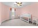 Cozy bedroom with a crib and soft neutral carpeting and pink walls at 116 Edgeview Ct, Dallas, GA 30157
