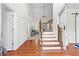 View of the foyer showing an open floor plan, hardwood floors, staircase and view into living room and a closed room at 116 Edgeview Ct, Dallas, GA 30157