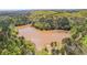 An aerial view shows a large pond surrounded by thick, lush trees at 116 Edgeview Ct, Dallas, GA 30157