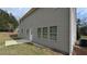 Back exterior view with light siding, a small patio, and level yard at 3005 Stonebrook Cv, Austell, GA 30106