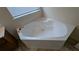 Corner soaking tub in a bright bathroom with tile flooring at 3005 Stonebrook Cv, Austell, GA 30106