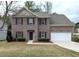 Charming two-story brick home features a manicured lawn, attached two-car garage, and welcoming front entrance at 3005 Stonebrook Cv, Austell, GA 30106