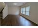 Spacious living room with wood-look flooring, staircase and ample natural light from three windows at 3005 Stonebrook Cv, Austell, GA 30106