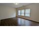 Open living room with wood-look floors and neutral walls, with three bright windows at 3005 Stonebrook Cv, Austell, GA 30106