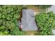 Aerial view of a home with a gray roof surrounded by lush green trees and a well-maintained yard at 3335 Maple Terrace Dr, Suwanee, GA 30024