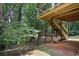 Backyard featuring a deck with stairs, patio, lush greenery, and natural landscaping at 3335 Maple Terrace Dr, Suwanee, GA 30024